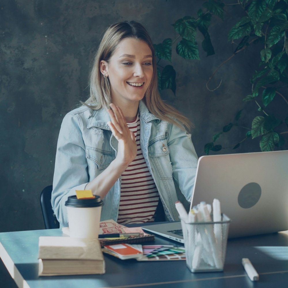 Femme souriante en visioconférence sur ordinateur portable