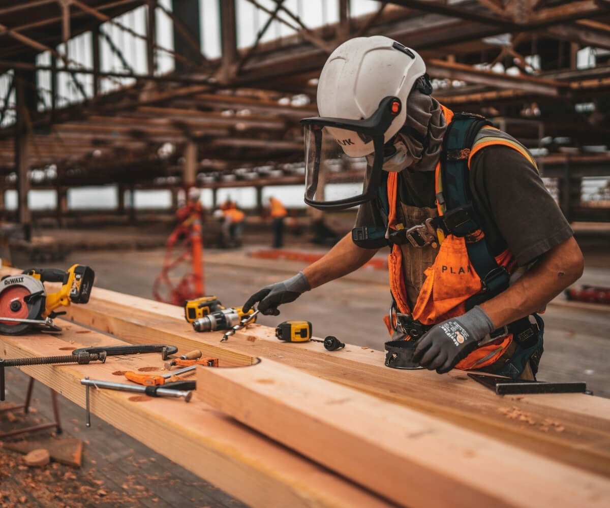 Ouvrier utilisant une perceuse sur un chantier de construction